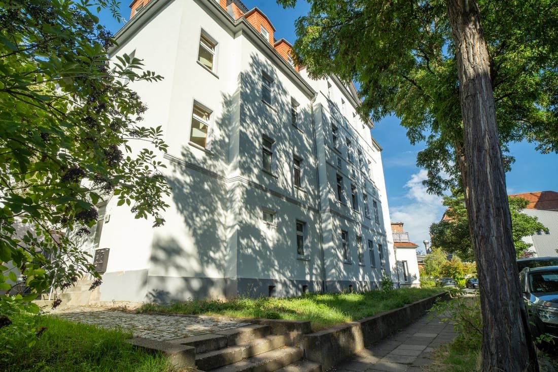 Seitenansicht des Eckhauses mit Schattenwurf der Bäume auf der Fassade